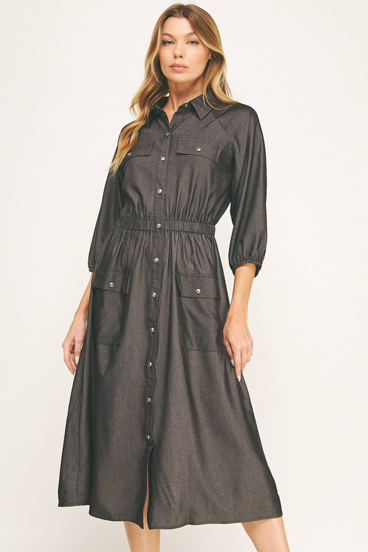Woman wearing a black button-up dress on a white background