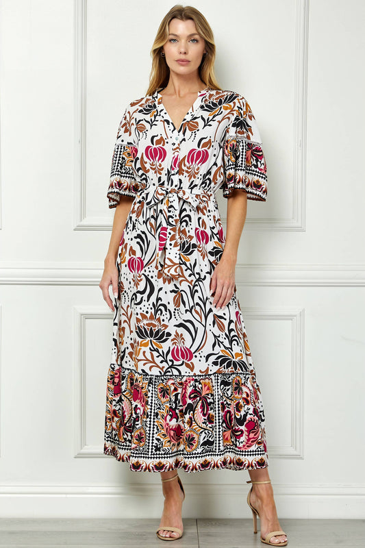 Woman wearing a floral dress against a white paneled wall