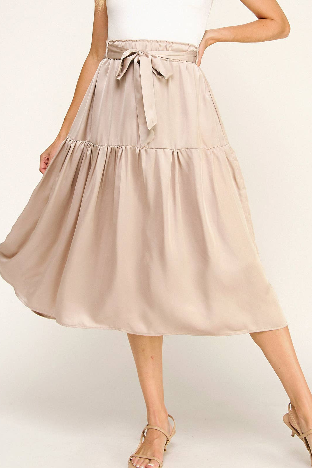 Beige skirt worn by a person on a white background