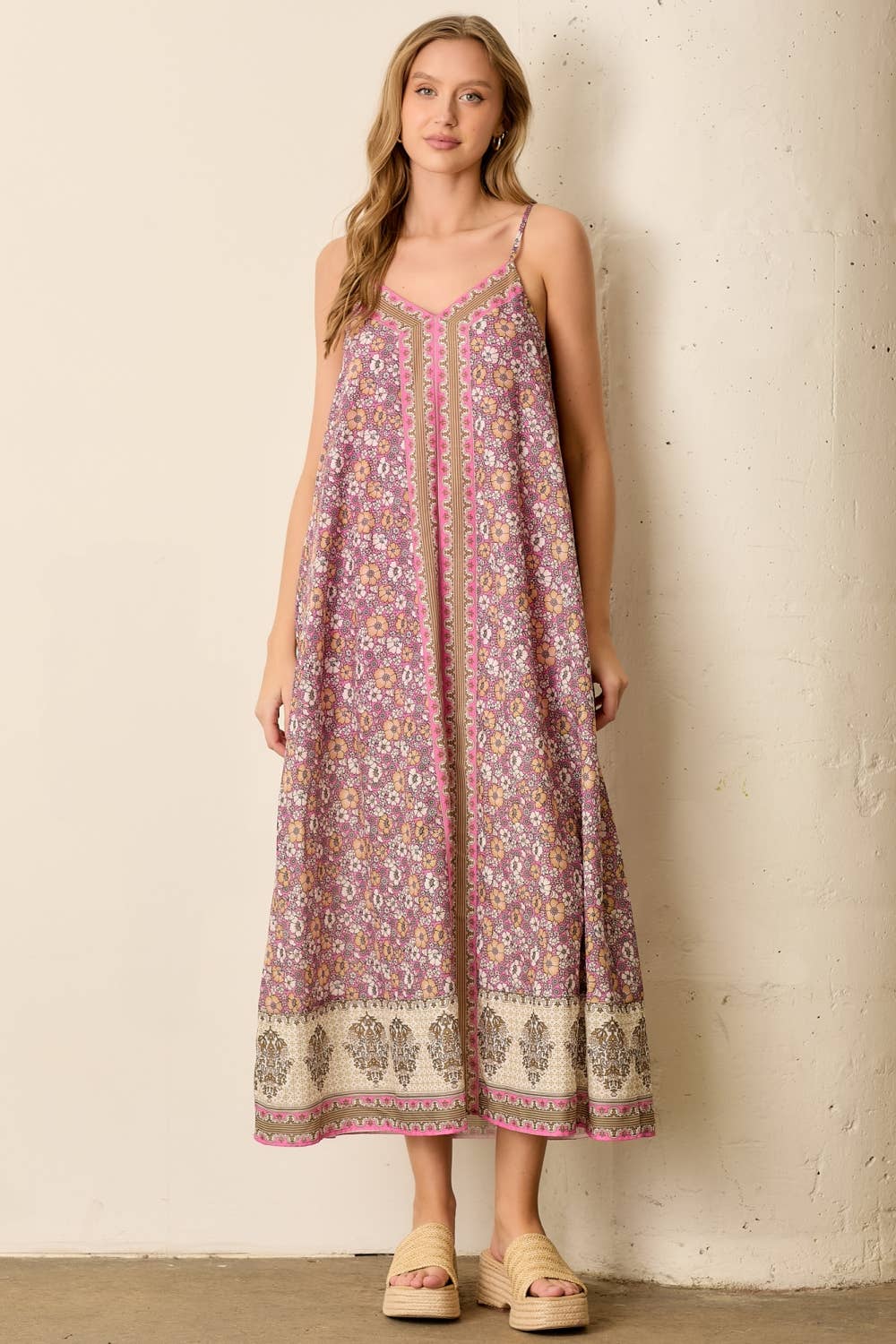 Woman wearing a floral patterned dress against a plain background