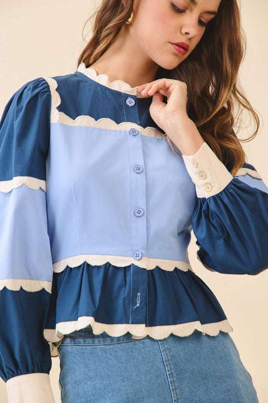Woman wearing a blue and white blouse with ruffled details on a beige background
