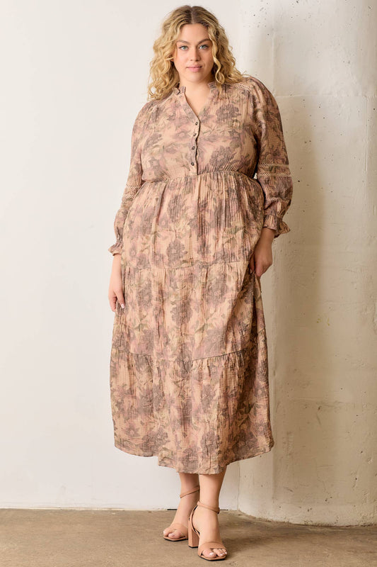 Woman wearing a patterned dress against a plain wall