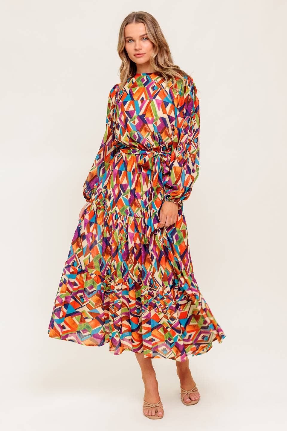 Woman wearing a colorful geometric patterned dress on a white background